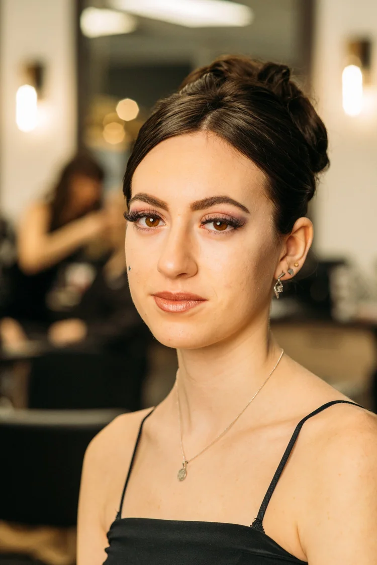 Formal makeup with winged eyeliner and neutral lips.